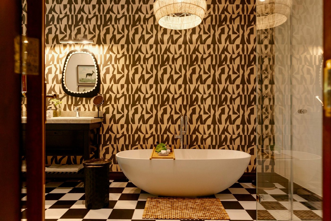 Freestanding bathtub beneath a leopard-print mural at Buhala Lodge