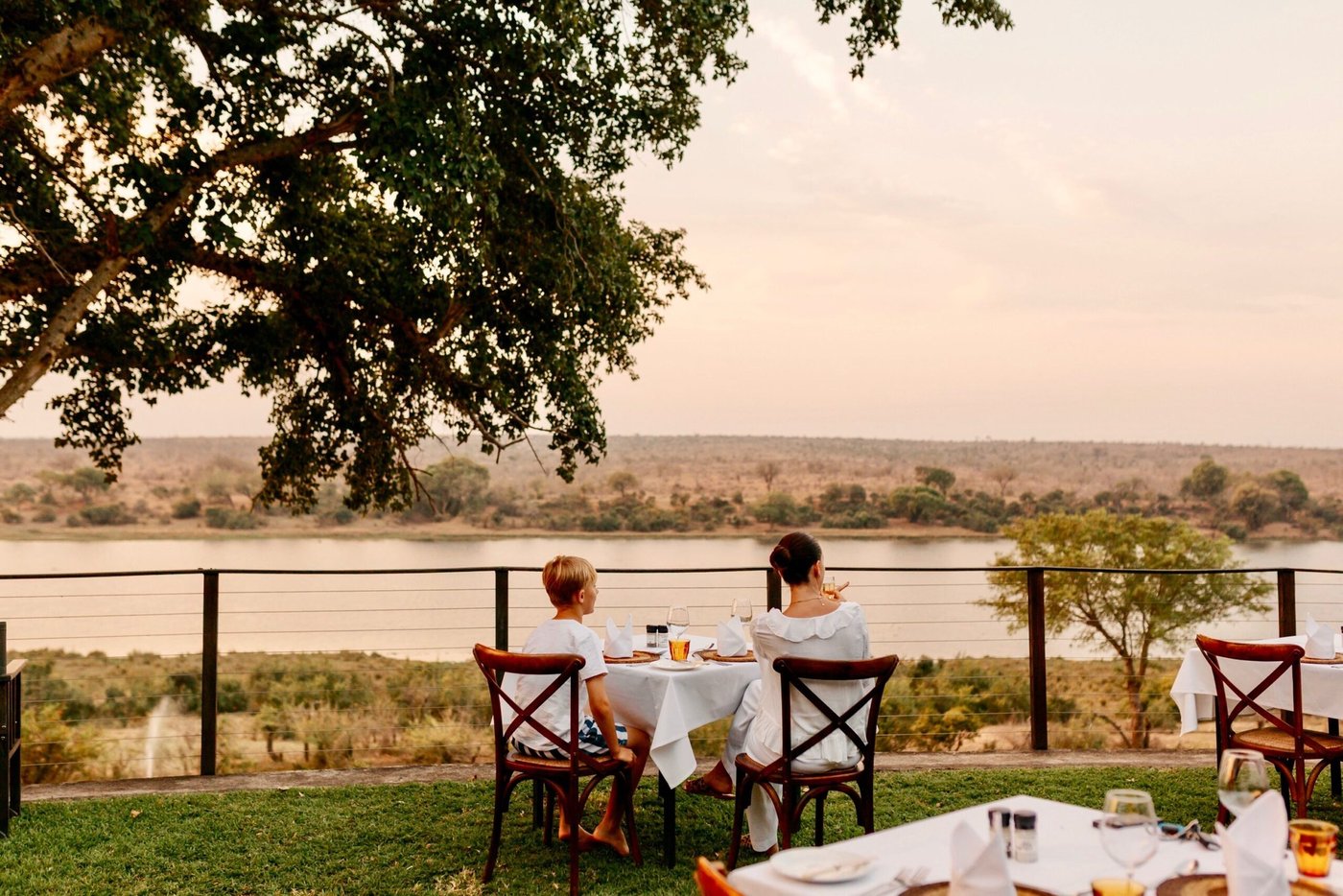 Riverside dining table set for breakfast overlooking the water at Buhala Lodge