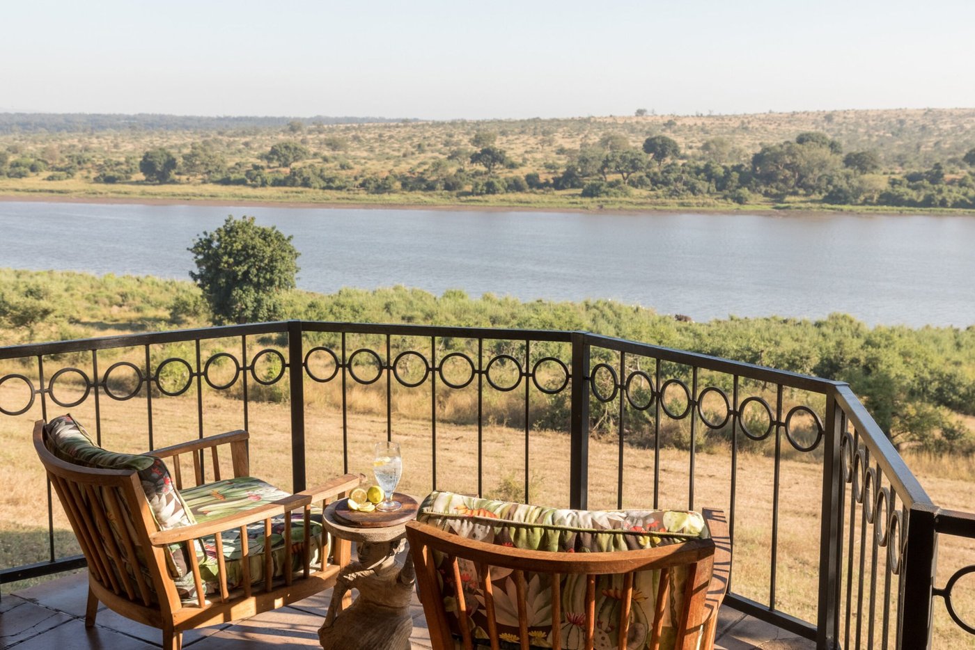 Private balcony with wicker chairs overlooking the river at Buhala Lodge