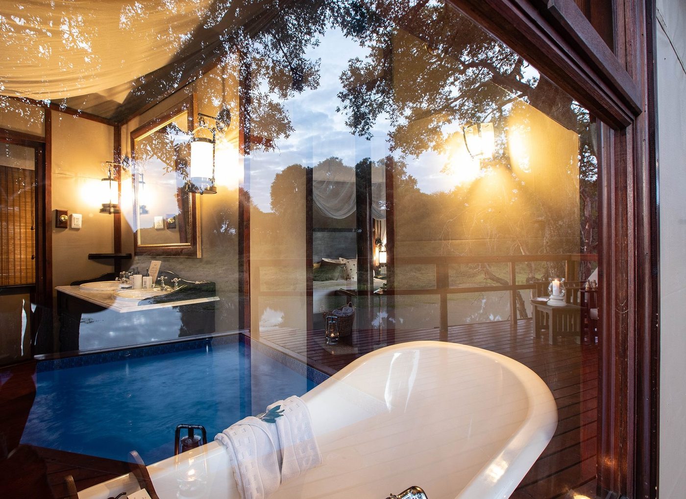 Freestanding bathtub and plunge pool beside glass doors at Hamiltons Tented Camp