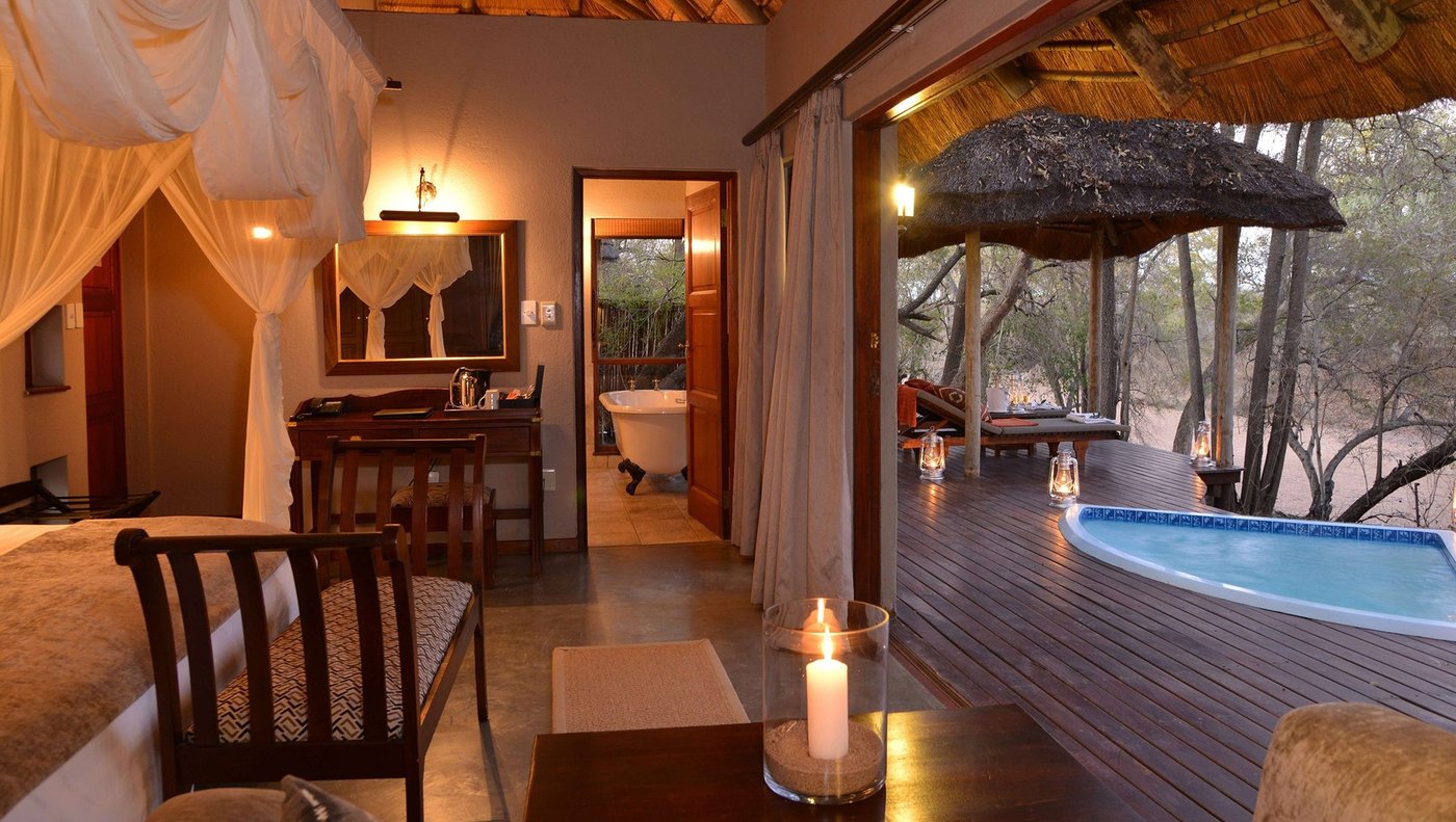 Bathroom with freestanding tub opening onto a private plunge pool at Imbali Safari Lodge