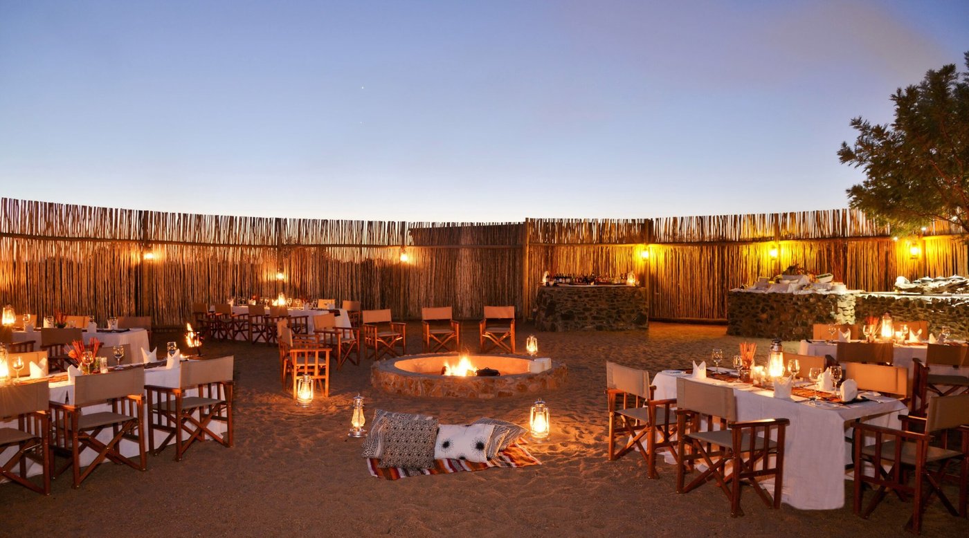 Boma dinner set among lantern-lit tables at Imbali Safari Lodge