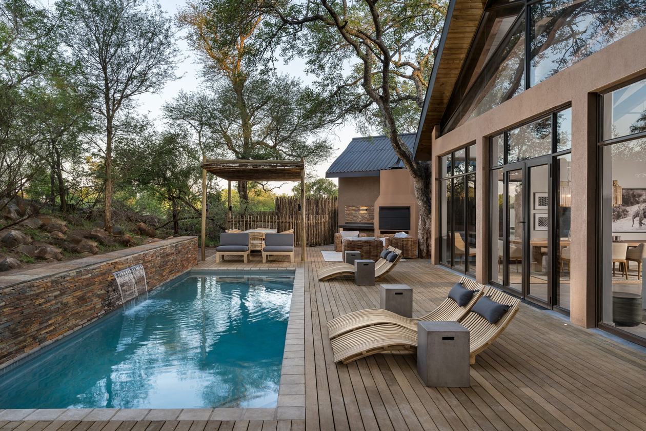 Private pool deck with loungers beside a guest villa at Kruger Gate Hotel