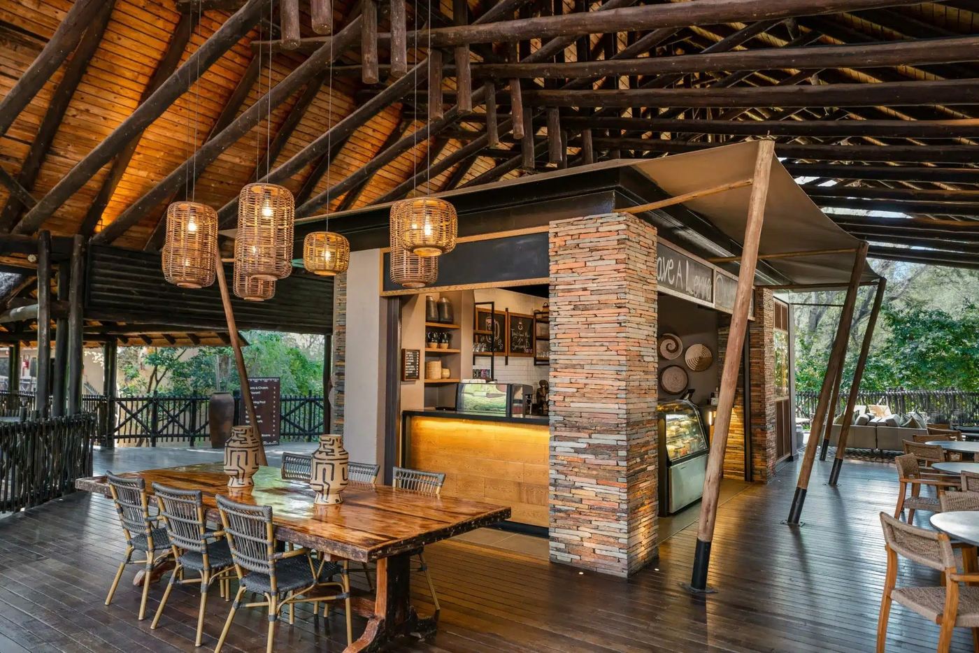 Timber-beamed bar and dining area with pendant lighting at Kruger Gate Hotel