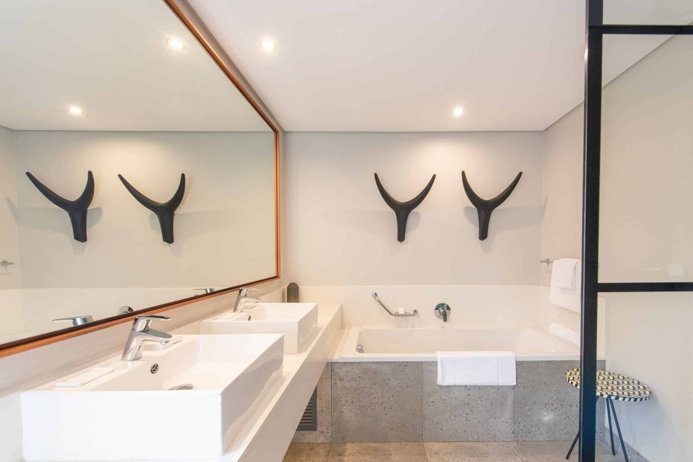 Bathroom with double vanity and kudu horn decor at Kruger Gate Hotel