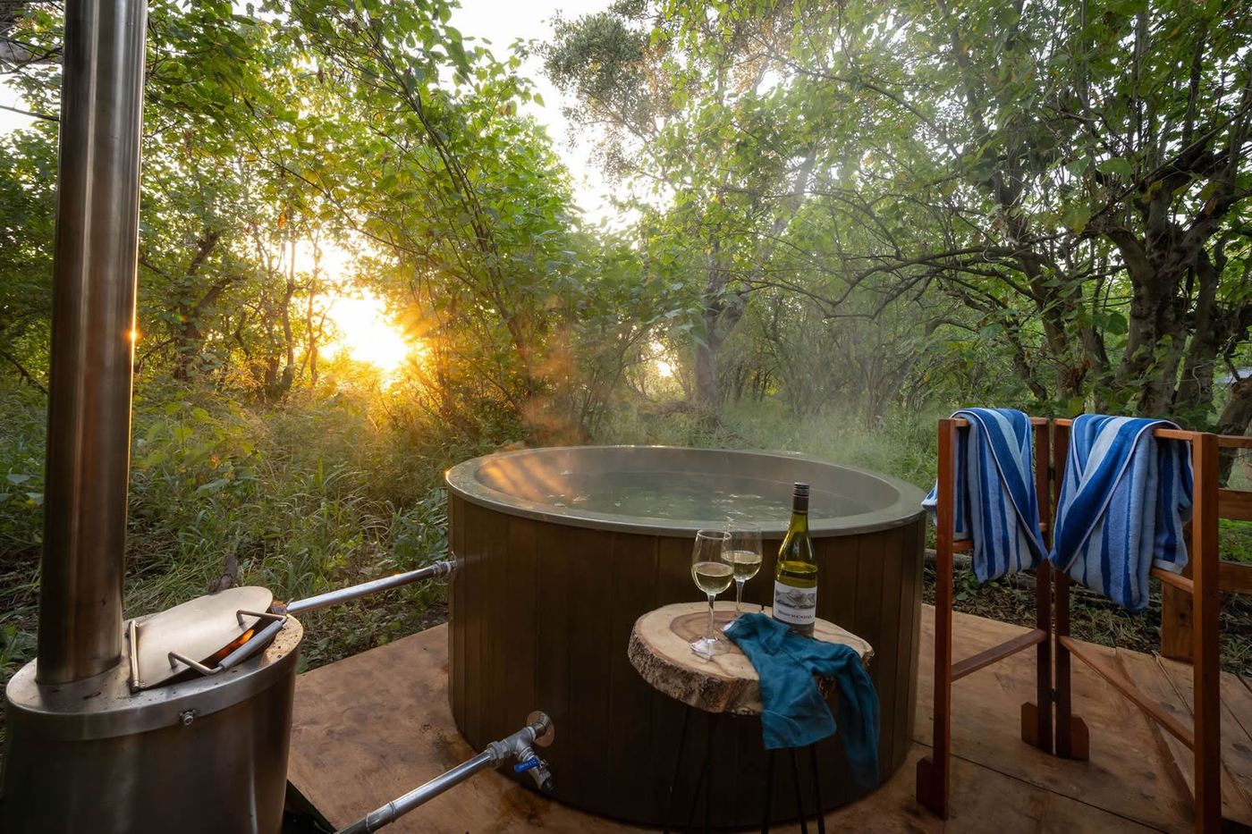 Outdoor bucket shower and copper tub among the trees at Kruger Untamed Satara Plains Camp