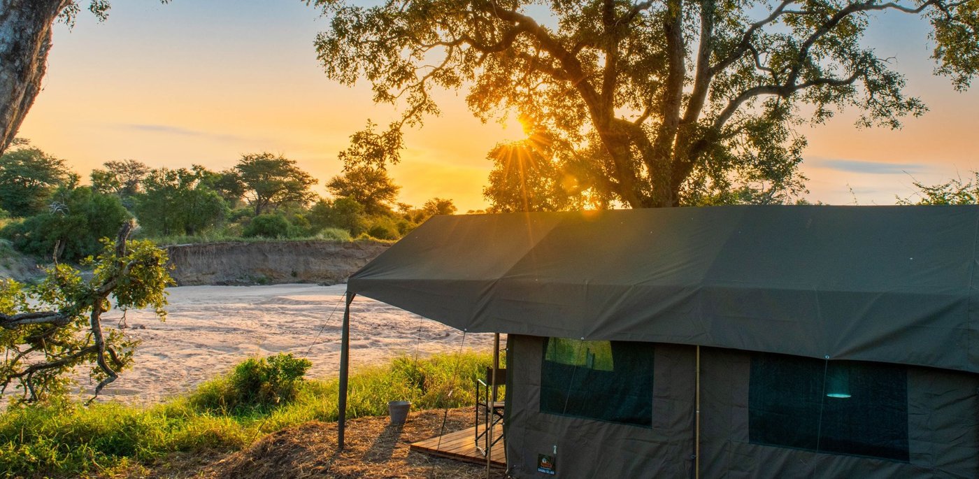Kruger Untamed Tshokwane River Camp safari tent on the riverbank at sunset in Kruger