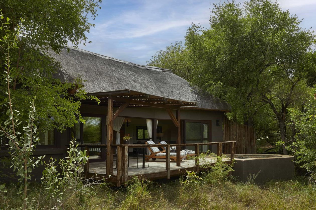 Lion Sands Tinga Lodge thatched suite nestled among riverine trees in Kruger