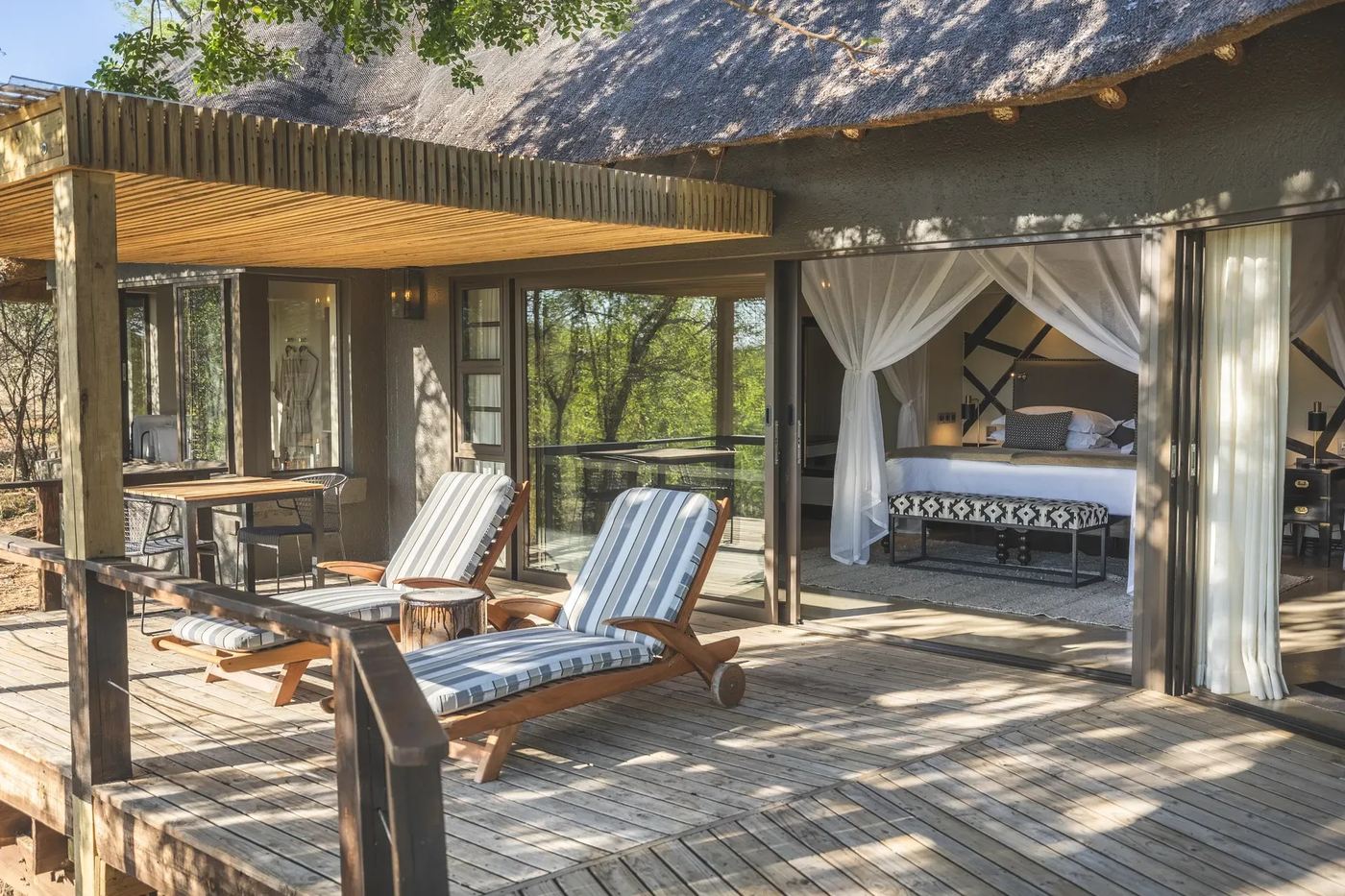 Covered deck with director's chairs beside the tented bedroom at Lion Sands Tinga Lodge