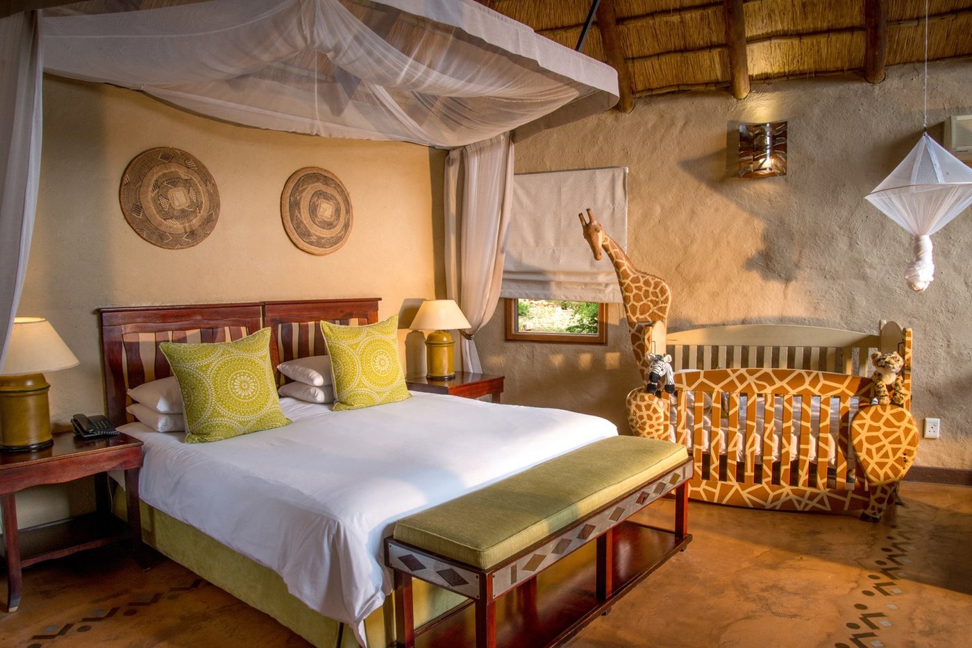 Bedroom with a giraffe-print bench and warm lighting at Lukimbi Safari Lodge