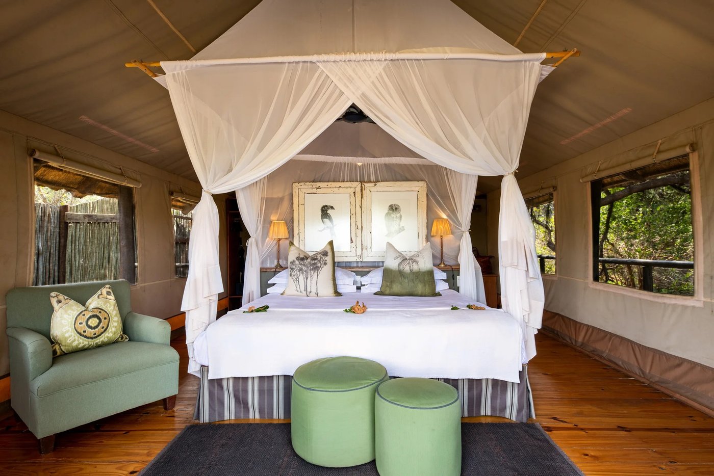 Canopy bed draped in white linen inside a safari tent at Pafuri Camp
