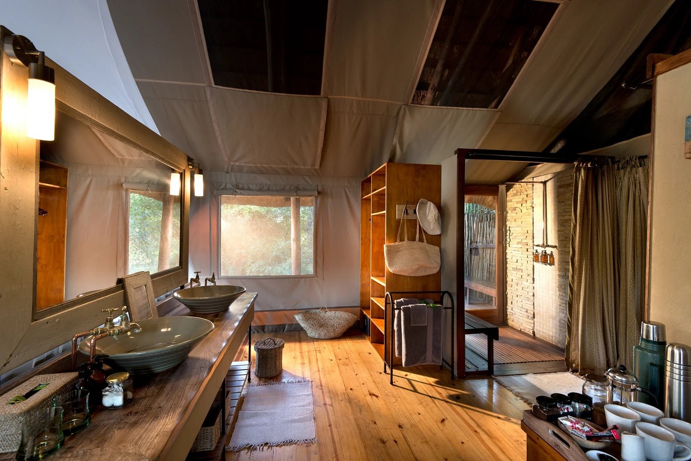 Vessel sink and walk-in shower lit by large windows at Pafuri Camp