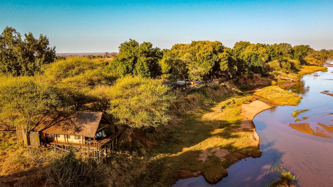 Aerial view of tented suites strung along the river at Pafuri Camp