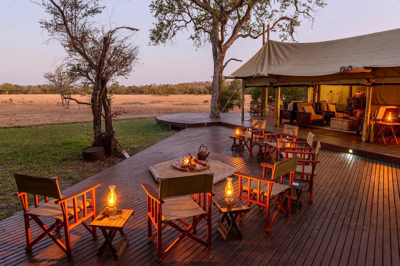 Plains Camp pool deck with lantern-lit seating at dusk in Kruger