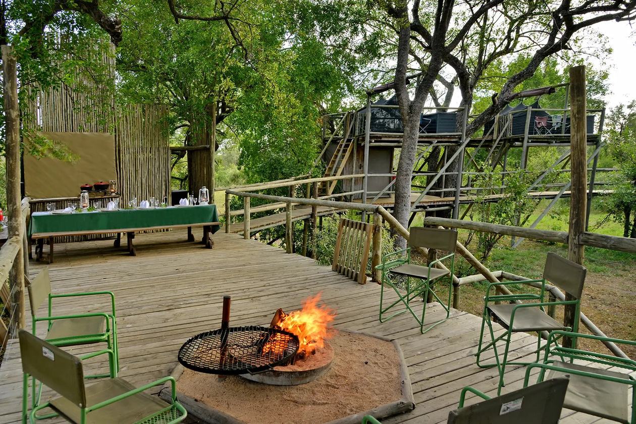 Rhino Post Safari Lodge deck with a central fire pit in Kruger