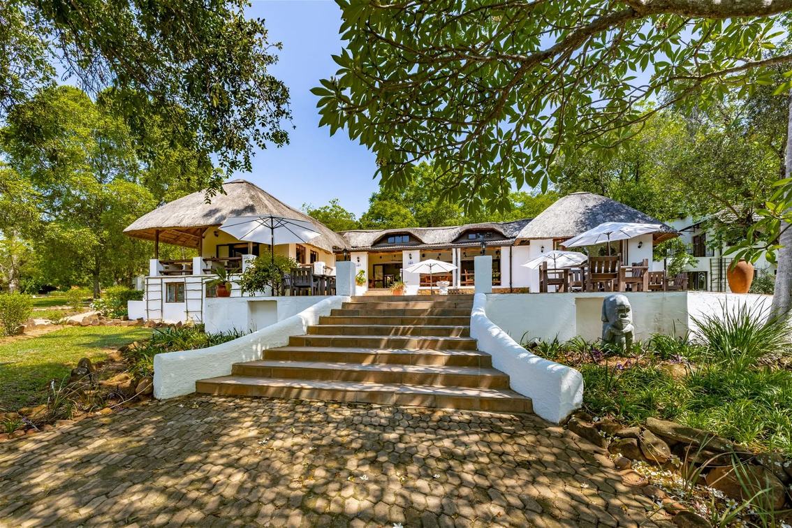 Rissington Inn colonial-style entrance with stone steps and gardens in Kruger