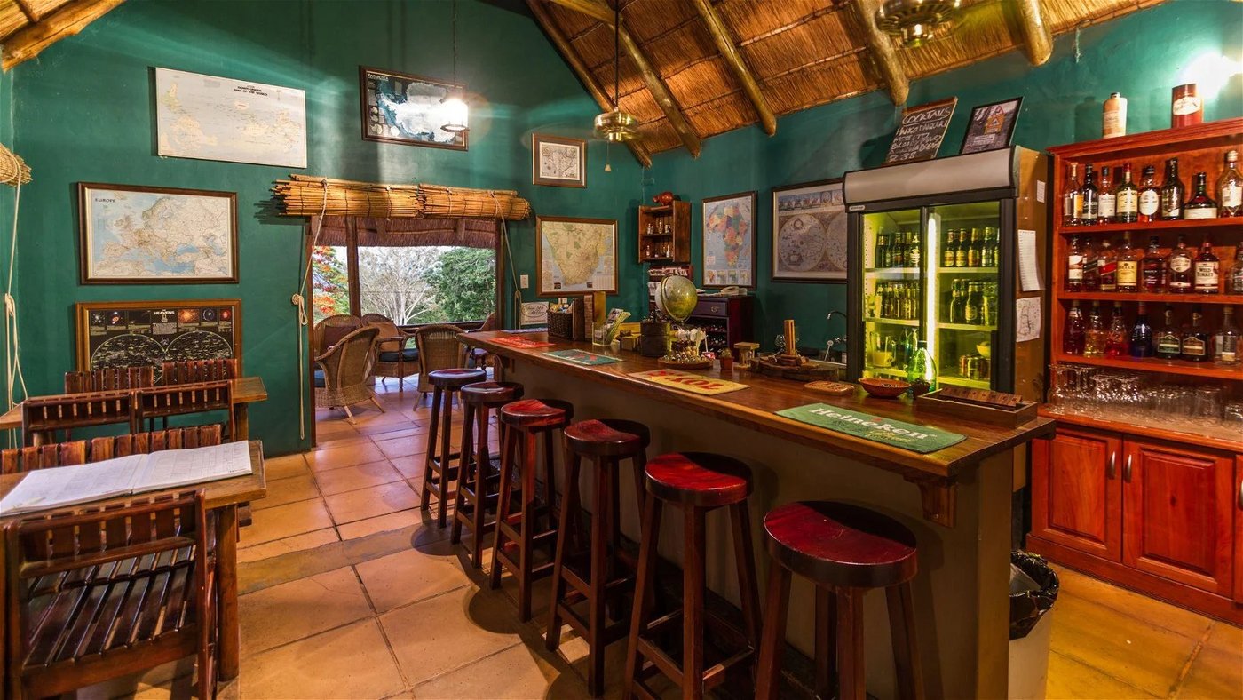 Map-lined bar and lounge with stocked shelves at Rissington Inn
