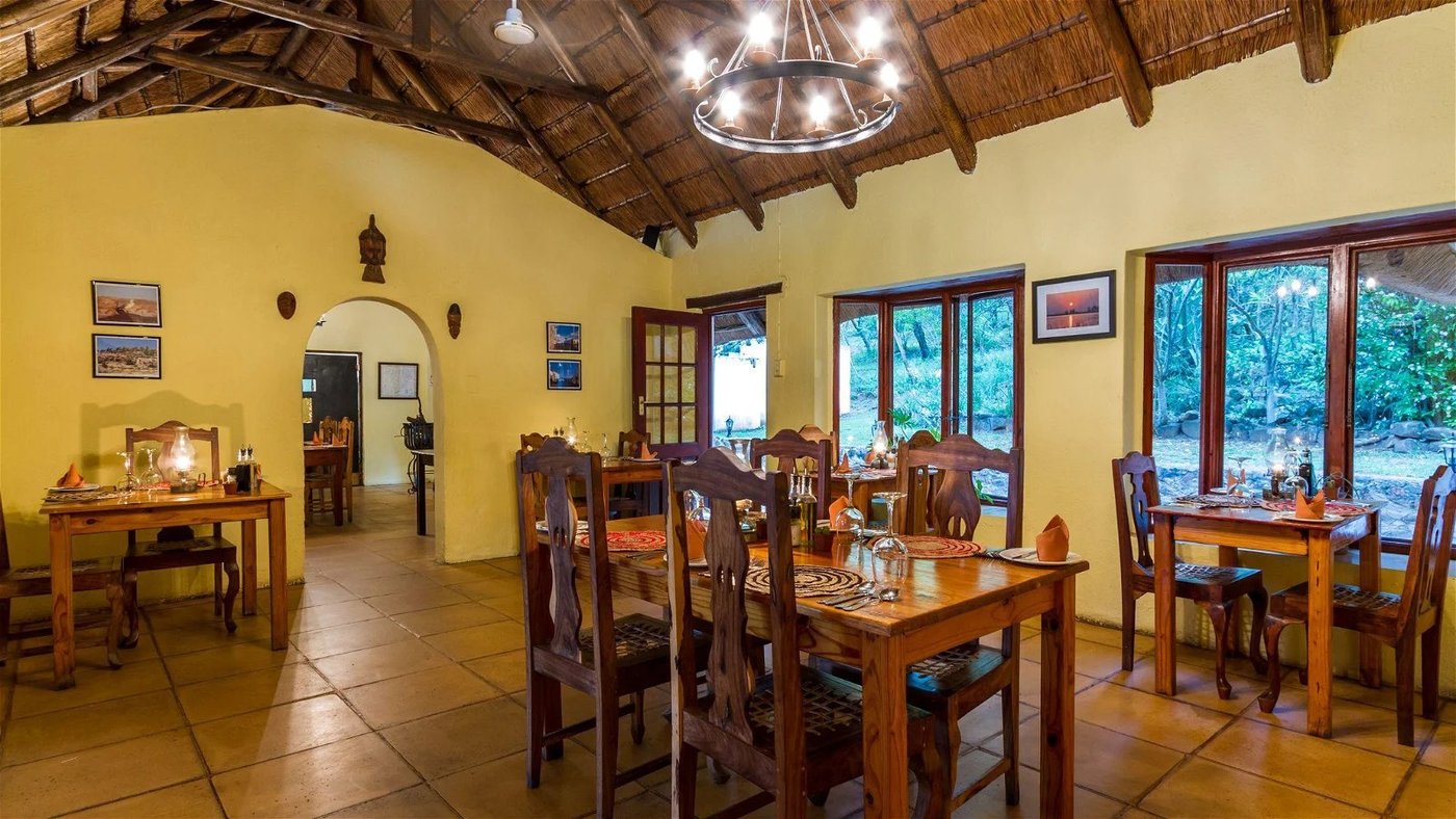 Thatched dining room with wooden tables set for breakfast at Rissington Inn