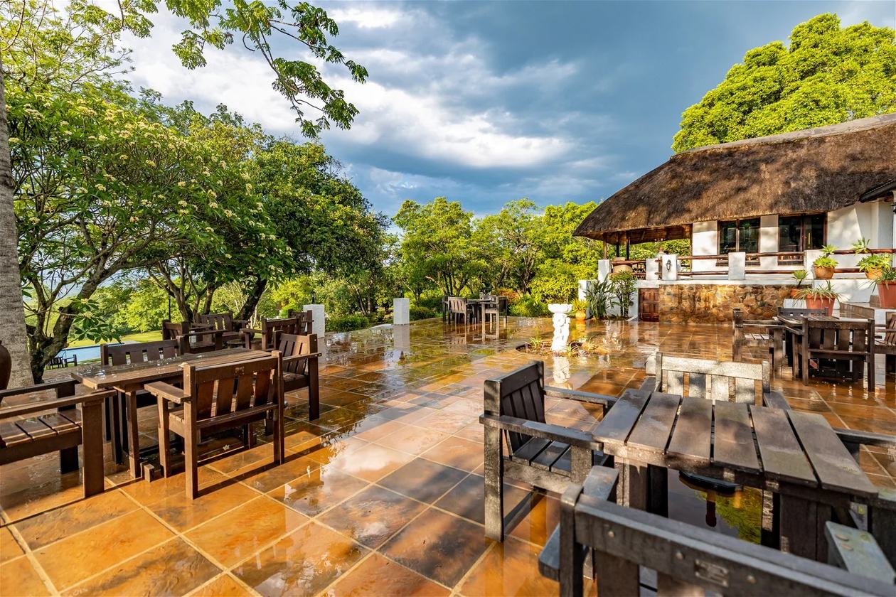 Covered courtyard with wet paving reflecting a stormy sky at Rissington Inn