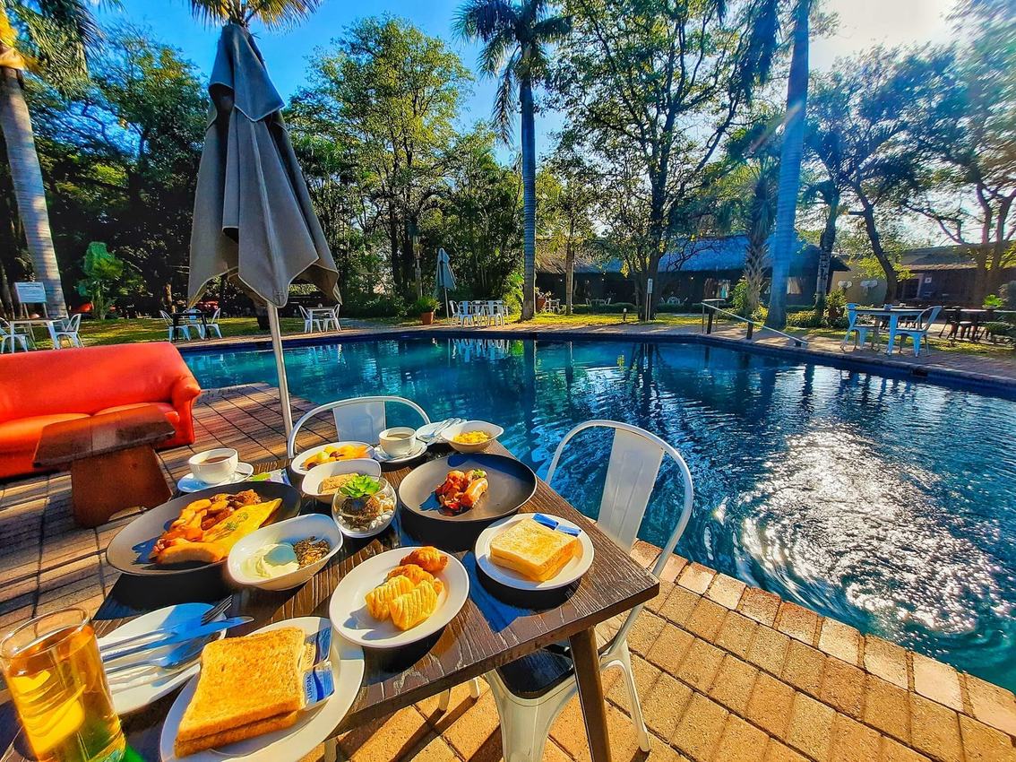Poolside breakfast table set beside the swimming pool at Sefapane Lodge