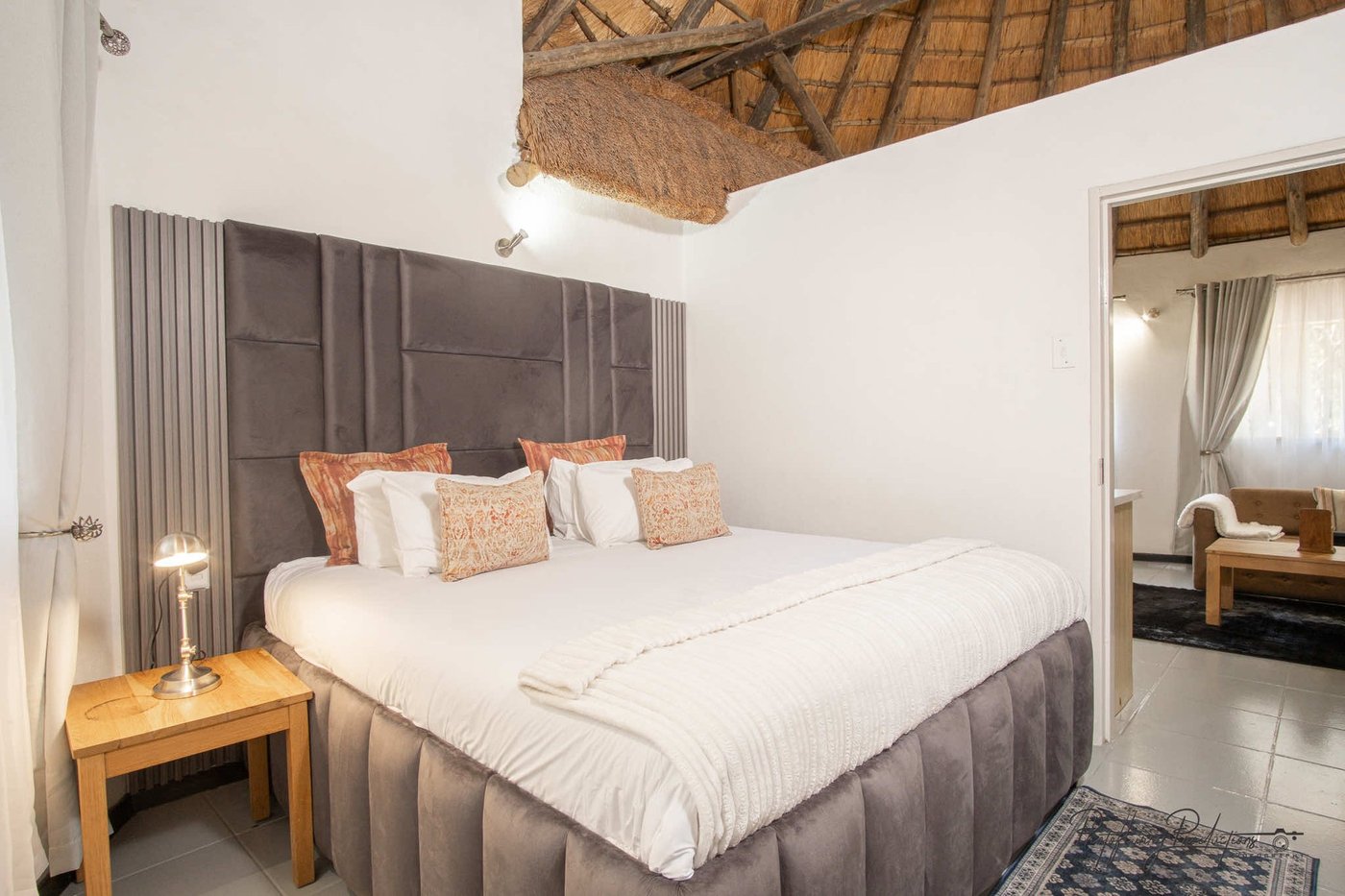 Bedroom with a tufted headboard and reading nook at Sefapane Lodge